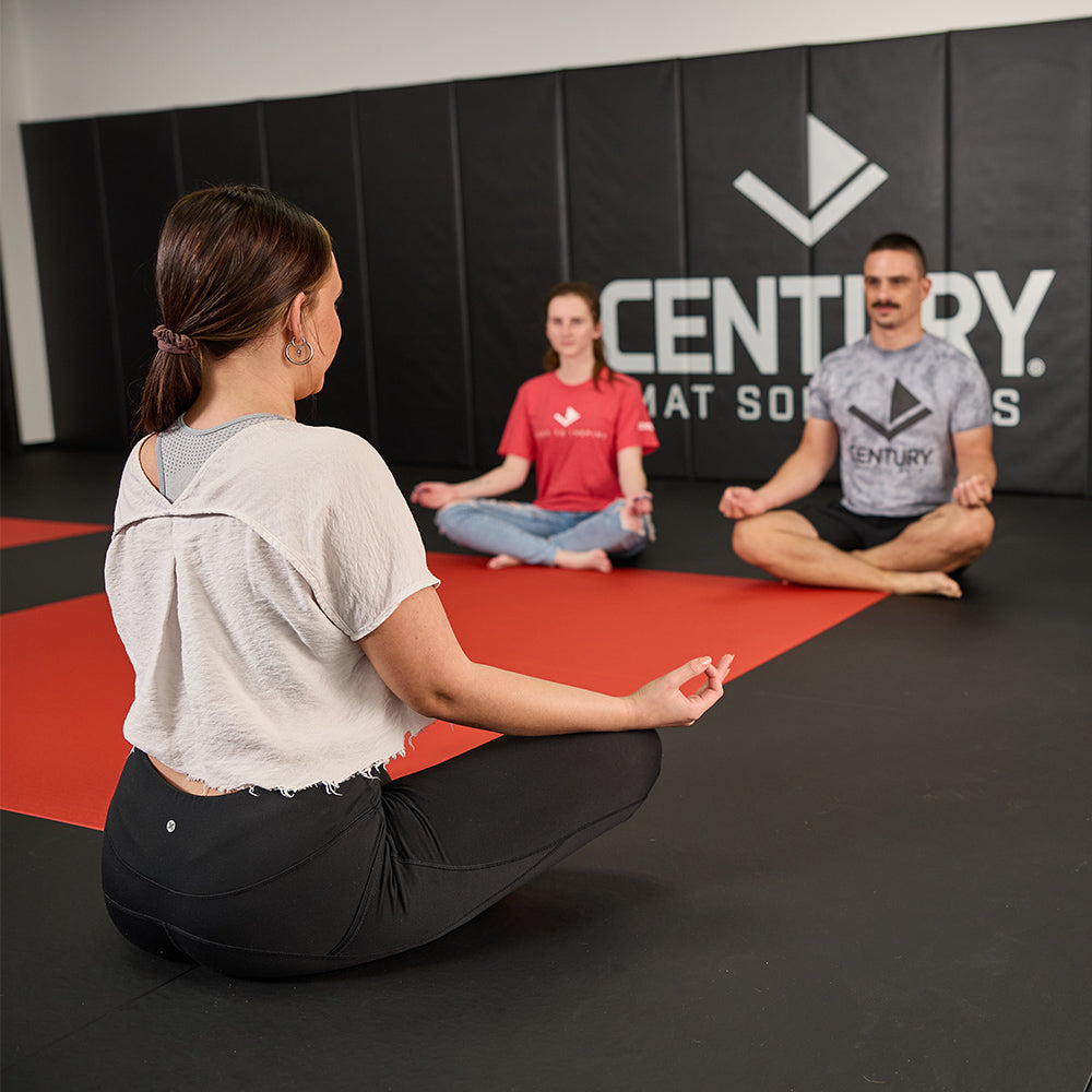 three people sitting on the mat